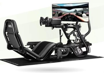 A Next Level Racing formula-style sim racing cockpit with a direct-drive wheel and a wide screen showing a race.
